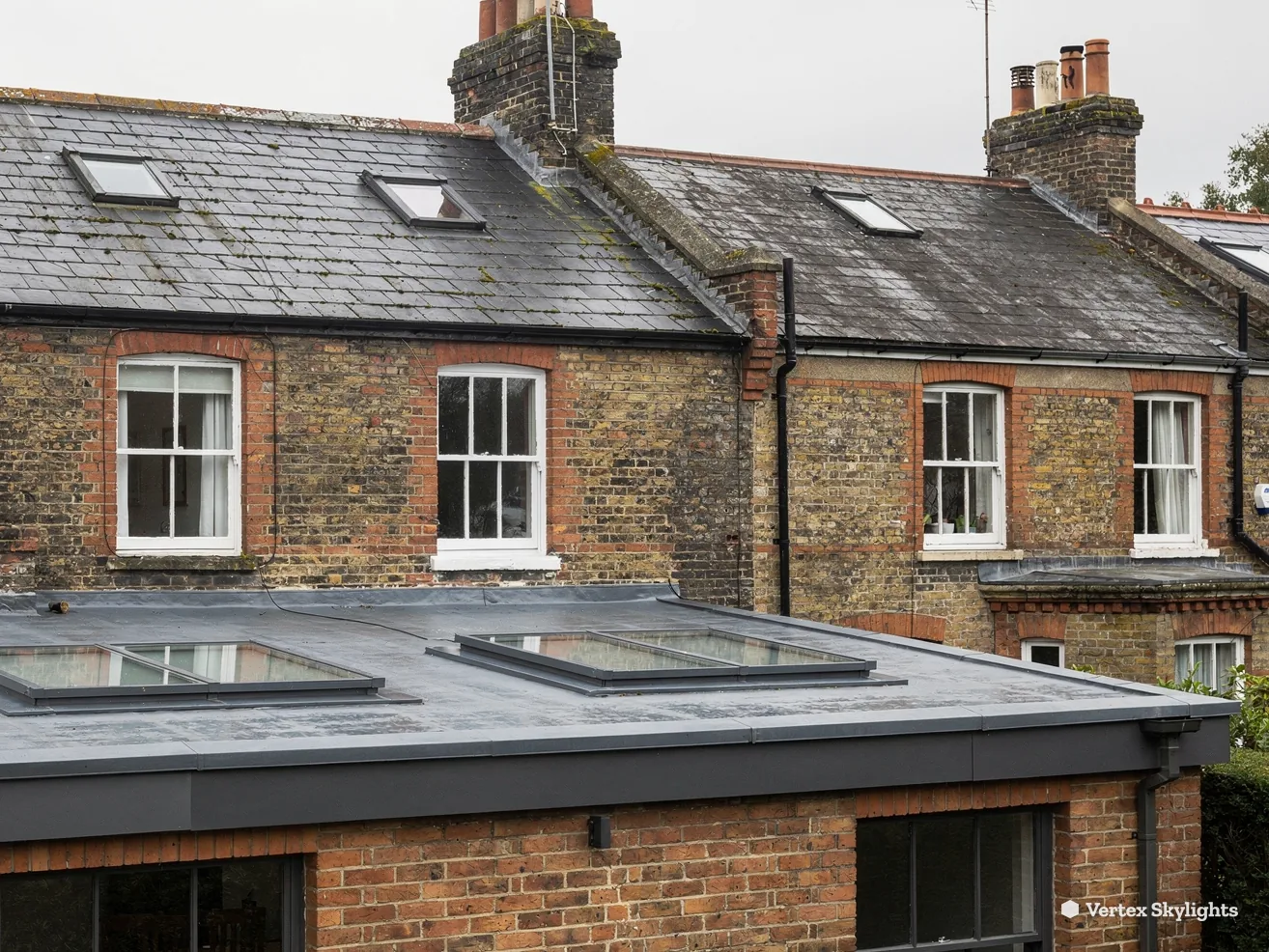 Two flat rooflights on a single-storey extension behind a brick terrace