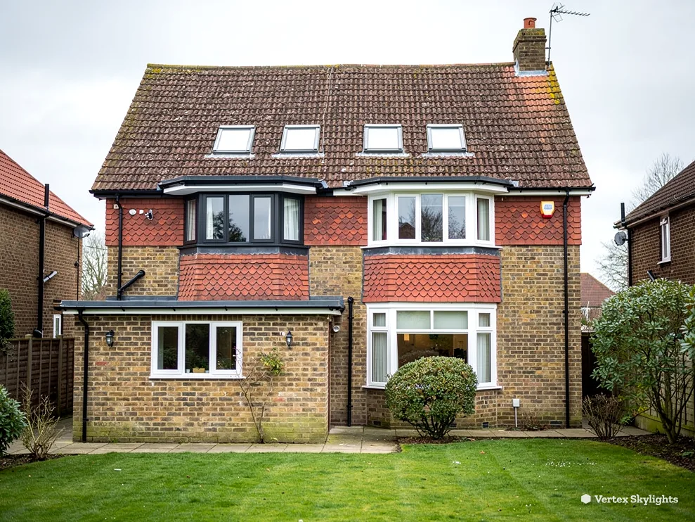 A brick and tile-hung semi with roof windows in the loft and a flat-roofed rear extension