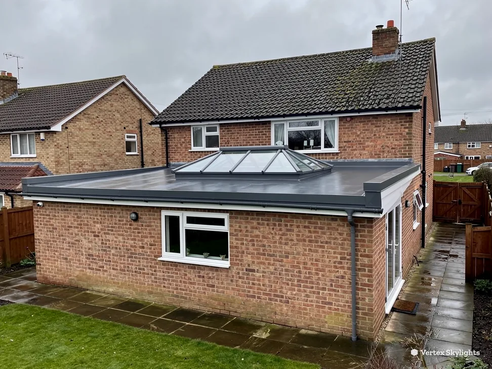 A roof lantern on a single-storey rear extension behind a brick house