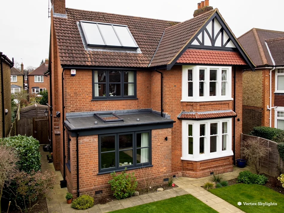 A brick and timber-gabled family house with roof windows in the loft