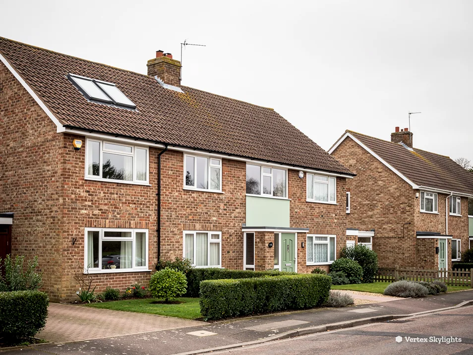 Brick semi-detached houses with a roof window, on a corner with front hedges