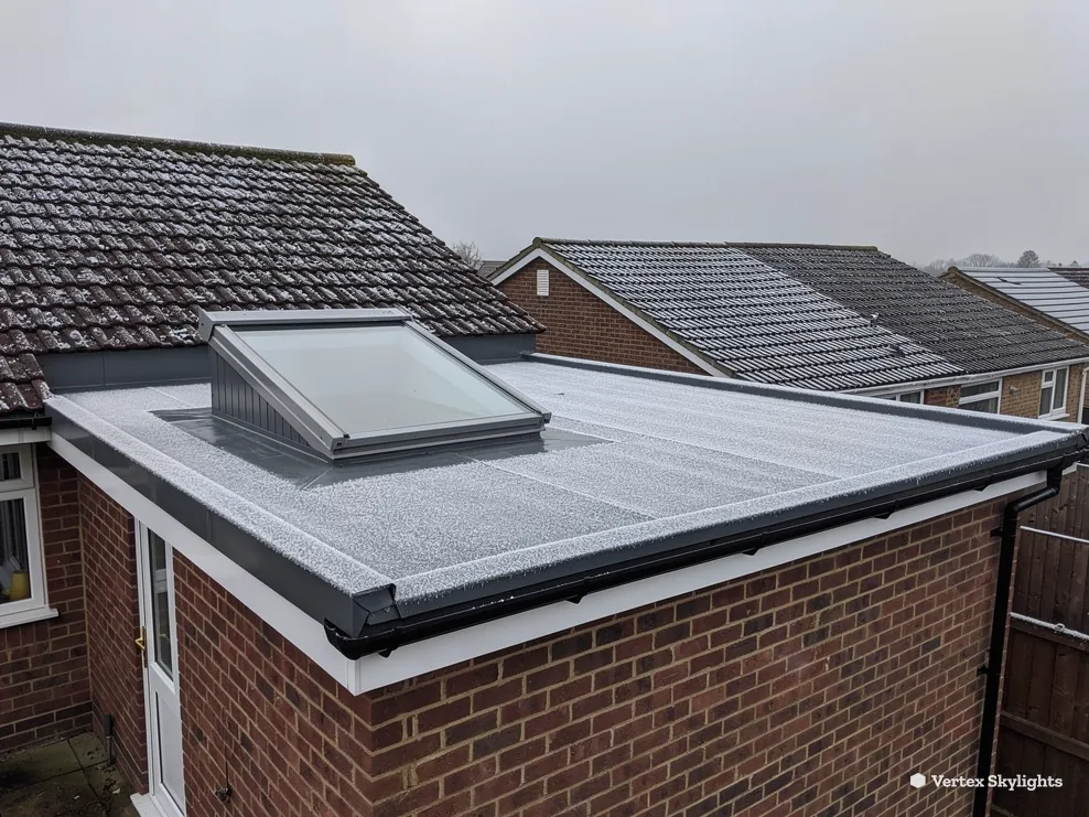 A flat rooflight with a raised frame on a brick extension roof