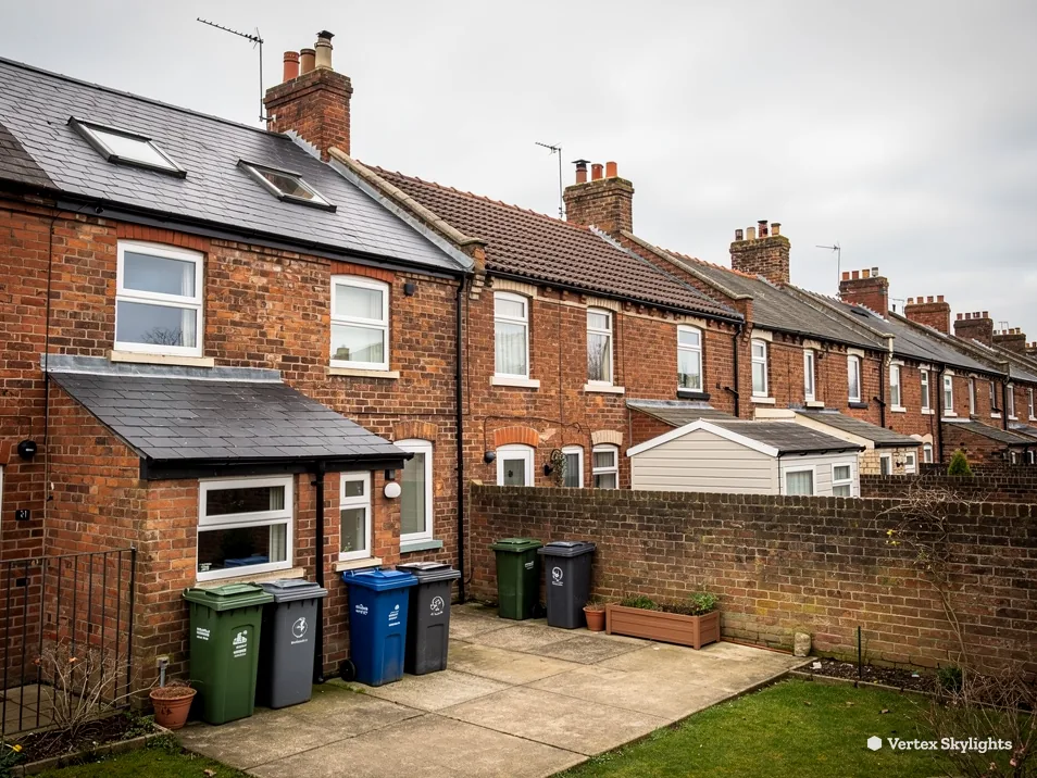 The back of a brick terrace with a roof window above a lean-to