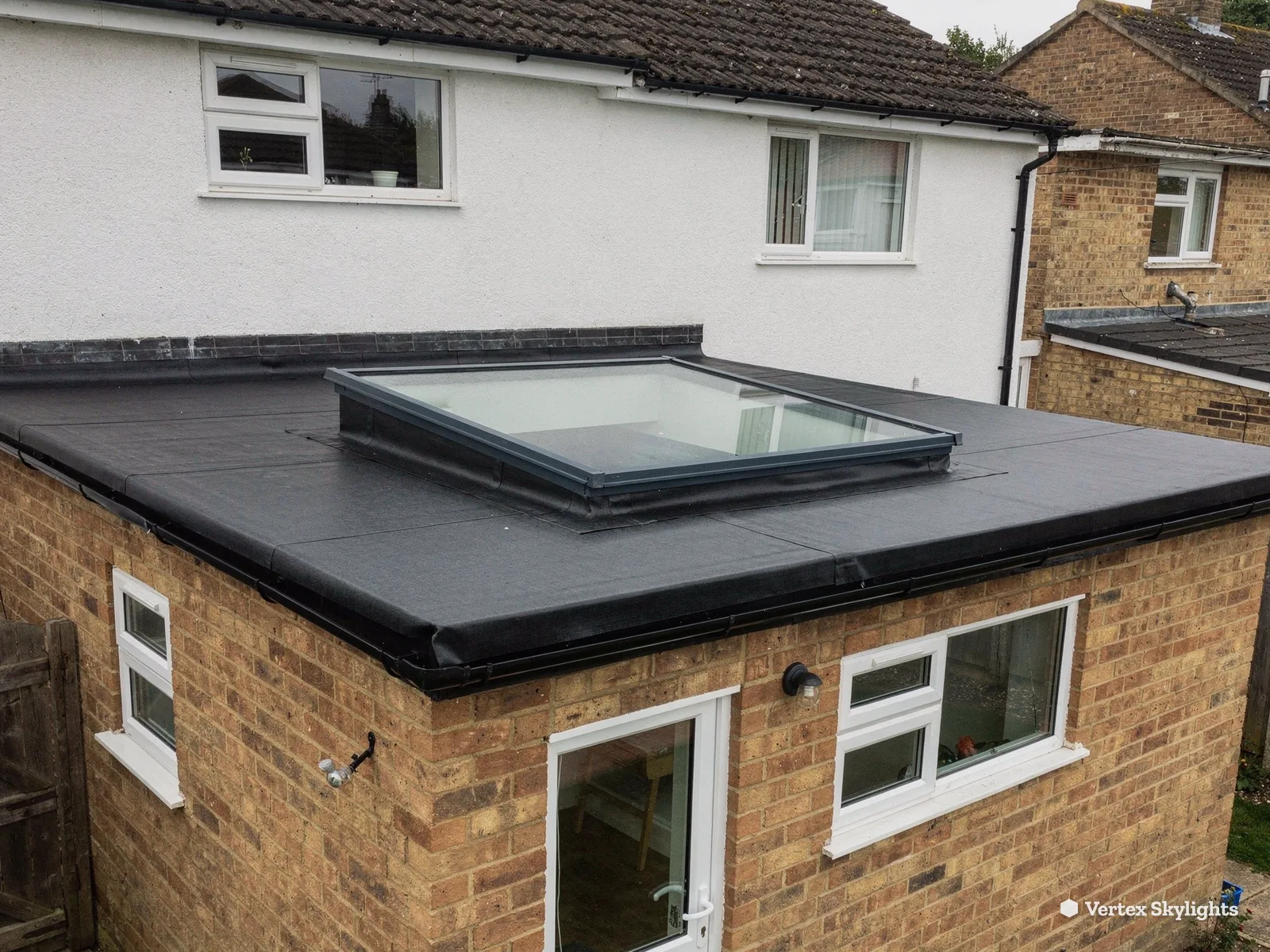 A flat rooflight on the extension of a brick and render house